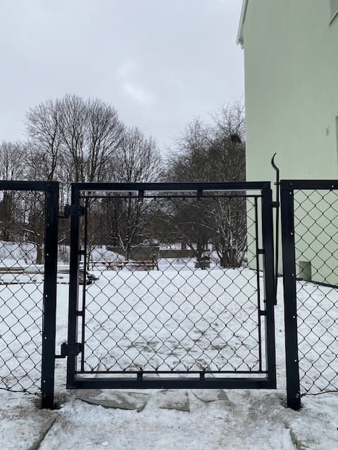 Sort flettverksgjerde og gangporter i Oslo borettslag